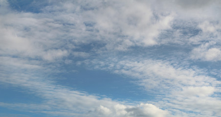 Obraz premium Blue bright sky with clouds, natural beautiful background. Soft daylight. Stock photo with empty space for text and design. 