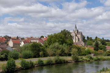Fototapeta na wymiar Church of Mareuil-sur-Ourc village and the Ourck canal in Ile-de-France region