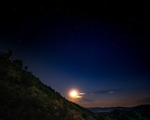 Landscape on a moonlit night. Hills in the foreground