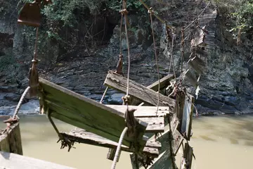 Gardinen Brücken Broken bridge made from wood and steel rope over a mountain river.  © Isnan