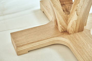 Round table solid wooden base. Modern wooden coffee table close-up. Modern furniture