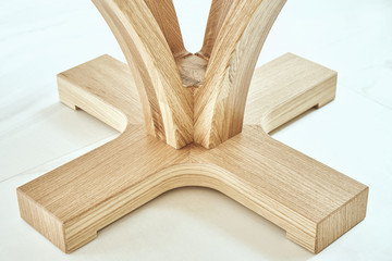Round table solid wooden base. Modern wooden coffee table close-up. Modern furniture
