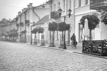 Grodno, Belarus, August 05, 2020: One of the old streets of the city in an early foggy morning. Black and white version