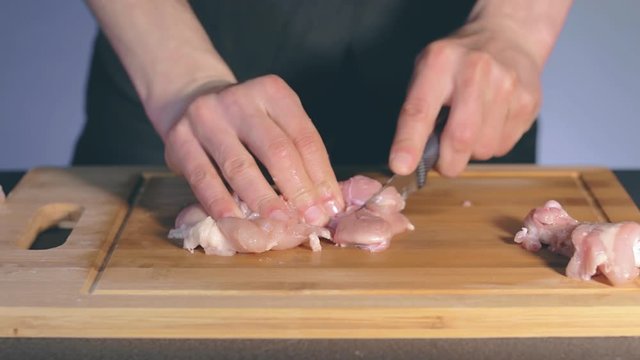 Chef in Black Uniform is Cutting Chicken Fillet. Butcher is Preparing Food Ingredients For Cooking - Slow Motion. Static Shot