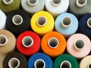 Threads of different colors on spools, standing vertically,top view,close up