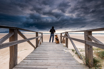 Adventure Man and Dog on Remote Beach. Active Outdoors Concept.