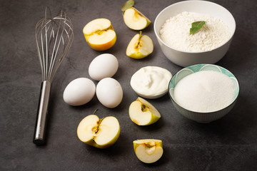 ingredients for apple pie on a dark background.