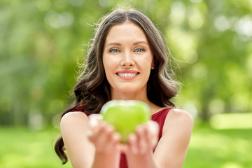 eco living, healthy eating and people concept - portrait of happy woman with green apple at summer...