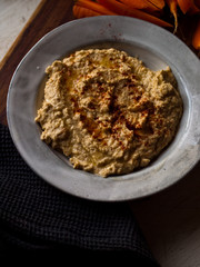 Chickpea hummus home made in natural light on farm table.