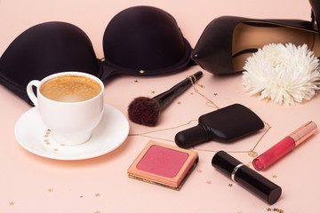 black coffee on the background of women's black lingerie and shoes.