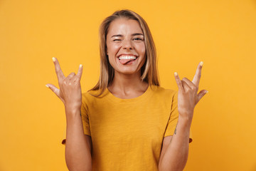 Image of excited woman winking and making horn gesture with fingers