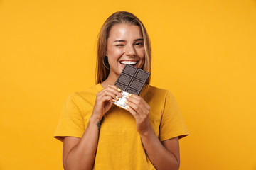 Image of blonde joyful woman winking and holding chocolate