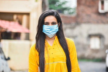 Fototapeta premium Portrait of Indian girl in mask staring at camera.