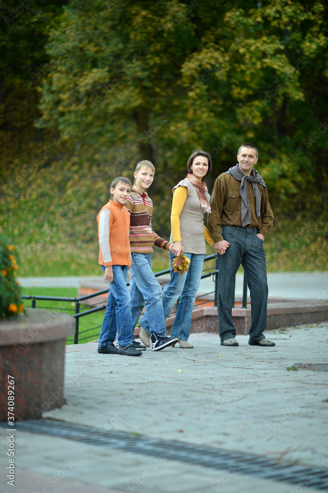 Wall mural family of four walking in autumn park