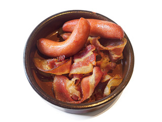 Sausages and bacon on a plate on white background