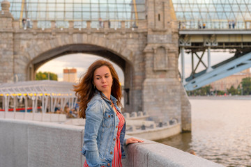 A young woman walks in the Park on the embankment in Moscow