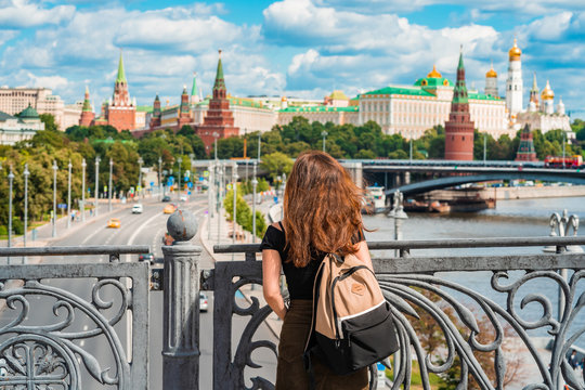 Rear view of a woman with backpack standing on a bridge in front of the Kremlin in Moscow, Russia