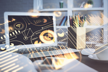 Computer on desktop in office with technology theme hologram. Double exposure. Tech concept.