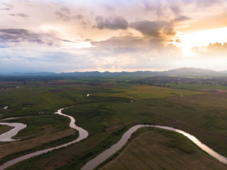 Scenic landscape aerial view of field river and basin against a natural mountain, Drone shot tropical landscape with noise and grain processed