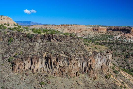Landscape of arid pink canyons and mesas, Jemez Mountains, New Mexico, USA. Travel in Southwest wilderness under blue sky
