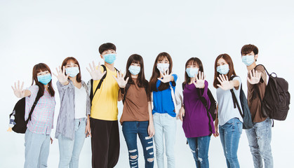 young student group wearing protective medical face masks standing together with stop gesture