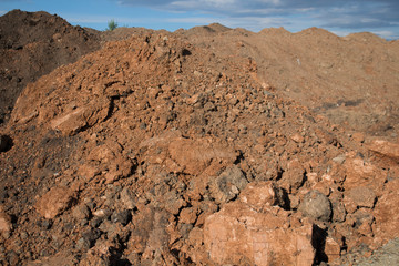 Red clay against blue sky. Red clay background.