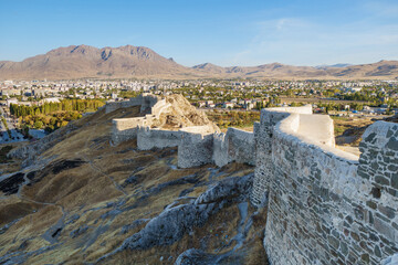 View onto walls & towers of Van Fortress, Van, Turkey. Castle was founded in 9 century BC by Urartians. Now it's favorite place for walking among locals & tourists. Modern city Van is on background