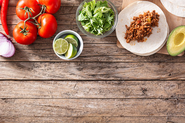 Mexican tacos ingredients on wooden table. Top view.Copy space