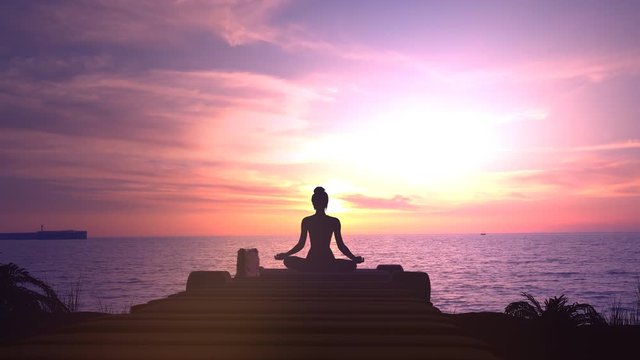 Meditation at magnificent sunset in the ocean.