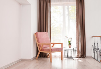 Stylish armchair near window in room
