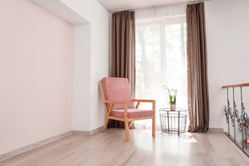 Stylish armchair near window in room