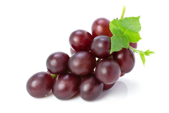 Cluster of ripe red grape fruit with green leaf isolated on white background. Full depth of field. Clipping path.