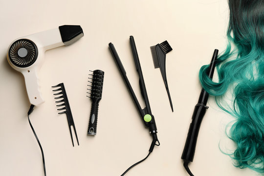 Unusual wig with hairdresser supplies on light background