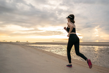 Woman jogging on beach in the morning.