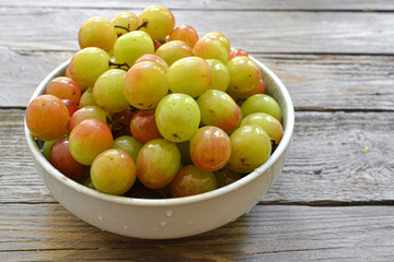 Ripe large grapes. Grapes in a plate isolated on a wooden background. Free space for text.