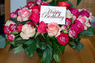 Bouquet of red, pink and yellow roses with happy birthday card. Template for birthday card.