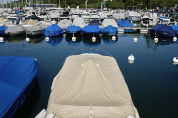 boats and yachts with a tarpaulin anchored in Lake Geneva Switzerland.