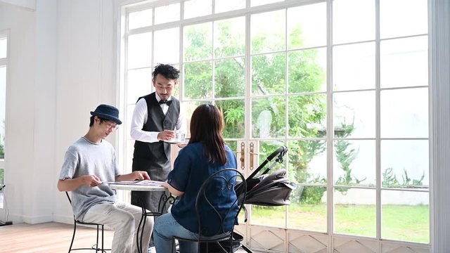 カフェで水を置いて接客するヒゲのイケメンマスターとお客様の4K動画
