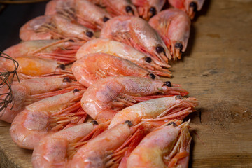 Boiled shrimp. Shrimps lie on a wooden board. Decorated around with dry greenery. Seafood