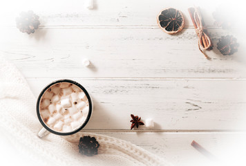  hot chocolate with marshmallows, cones, cinnamon sticks, white sweater on a white wooden background top view, place for inscription