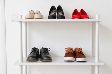 Stand with stylish shoes in interior of modern hall