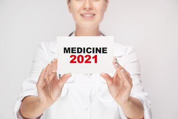 Doctor holding a pen with paper plate text MEDICINE 2021, medical concept