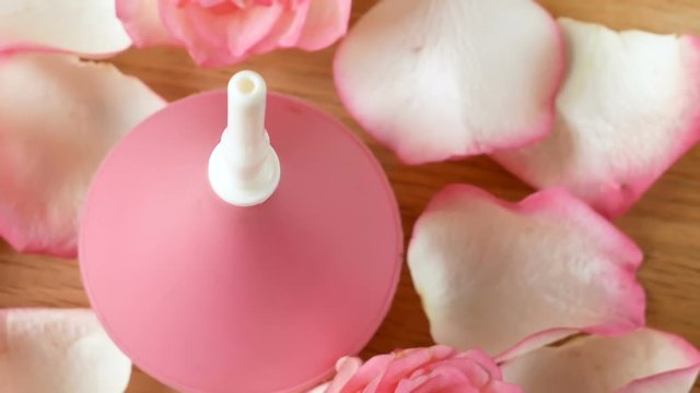 enema and rose petals spinning on a wooden table, mild constipation remedy concept