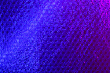 Bubble wrap in neon color. Abstract light blue and pink neon background texture in colorful gradient. Flat lay, copy space, top view. Trendy neon colors background.