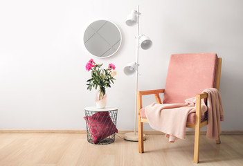 Stylish interior of room with mirror, table and armchair