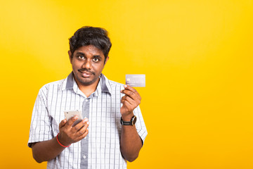 Closeup Asian happy portrait young black man holds a mobile smartphone and showing credit card for...