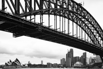 Black and white image of the Sydney Australia skyline as seen from under the  Sydney Bridge