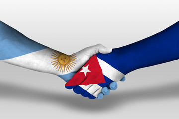 Handshake between cuba and argentina flags painted on hands, illustration with clipping path.