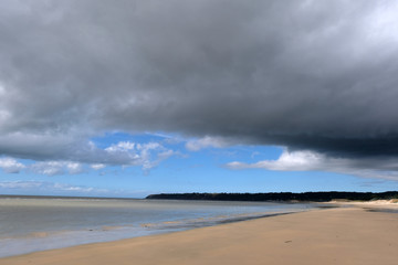 Plage Dragey-Ronthon à marée basse sous un ciel nuageux