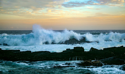 Sunset and storm waves on the ocean coast.